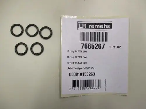 Fünf schwarze O-Ringe auf einer weißen Arbeitsfläche, daneben ein Etikett von Remeha mit Artikel- und Barcode-Informationen.